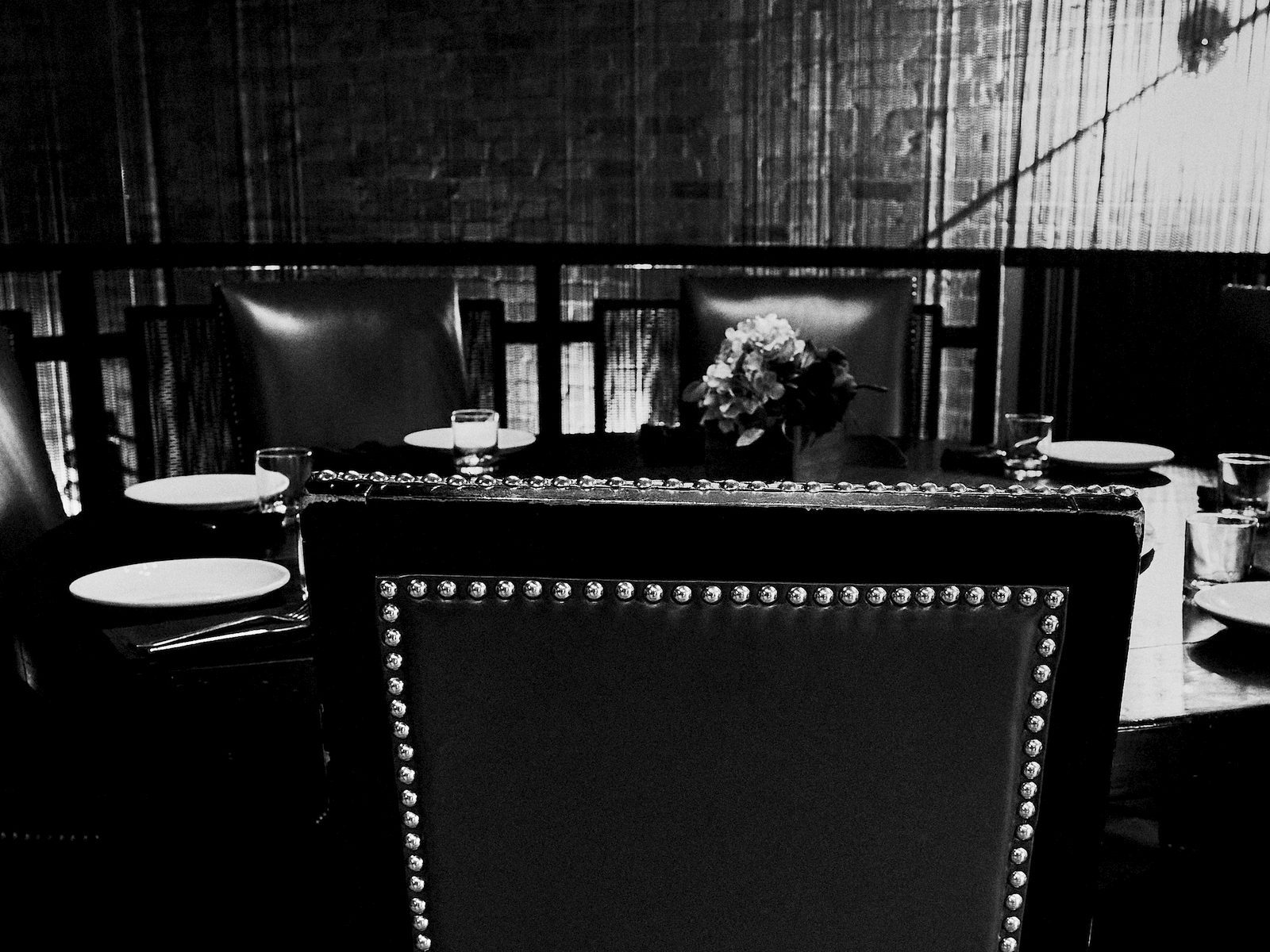 An empty chair pulled up to a table set for dinner